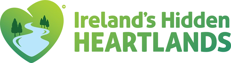 Logo featuring a green heart with trees and a winding river, representing Ireland’s Hidden Heartlands tourism initiative.