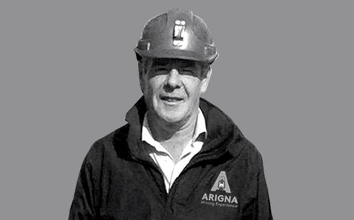A smiling man wearing a hard hat and Arigna Mining Experience jacket, representing the mining attraction in Ireland.